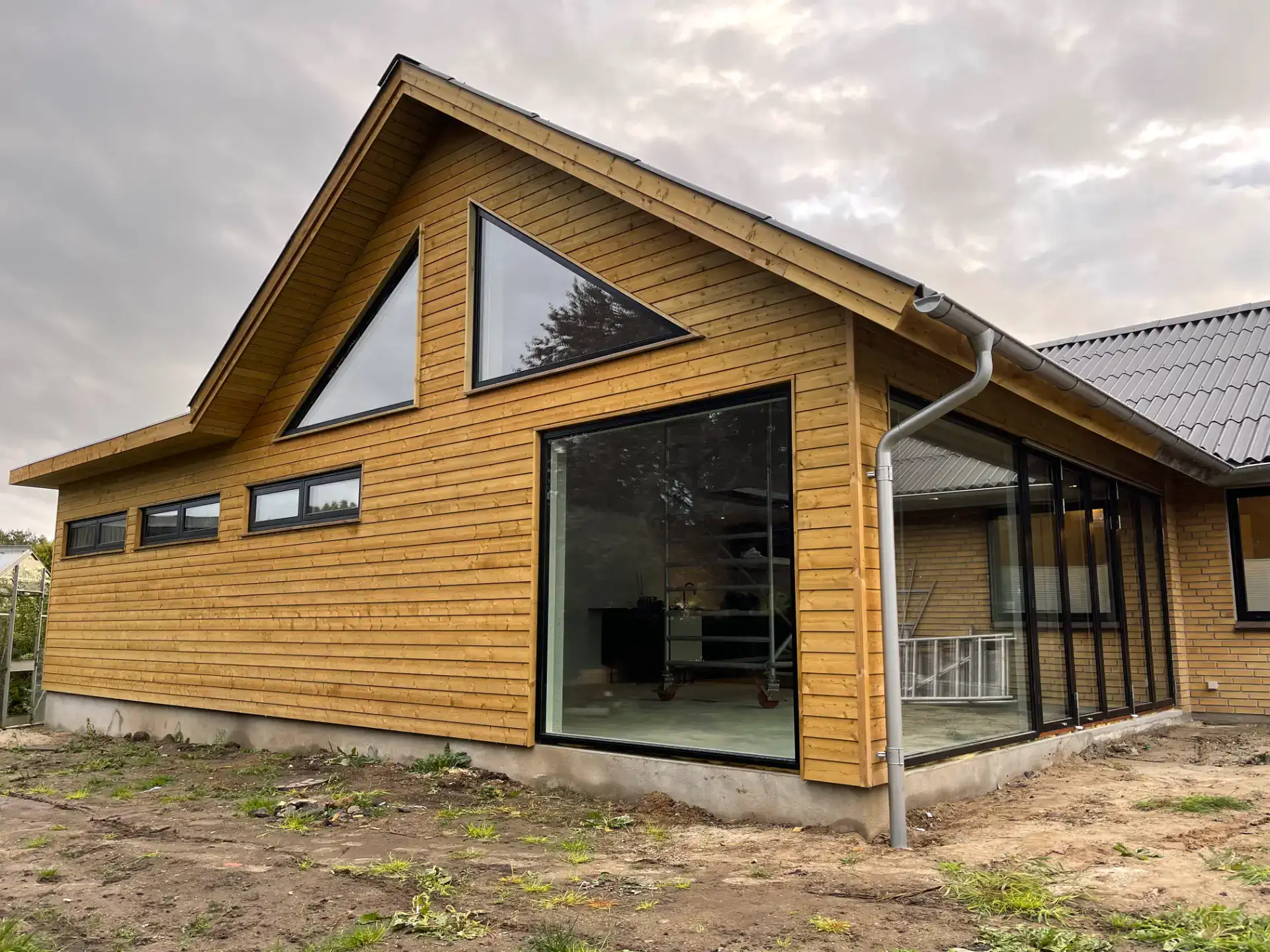 Nybygget træhus med store vinduer og moderne design, klar til indflytning.