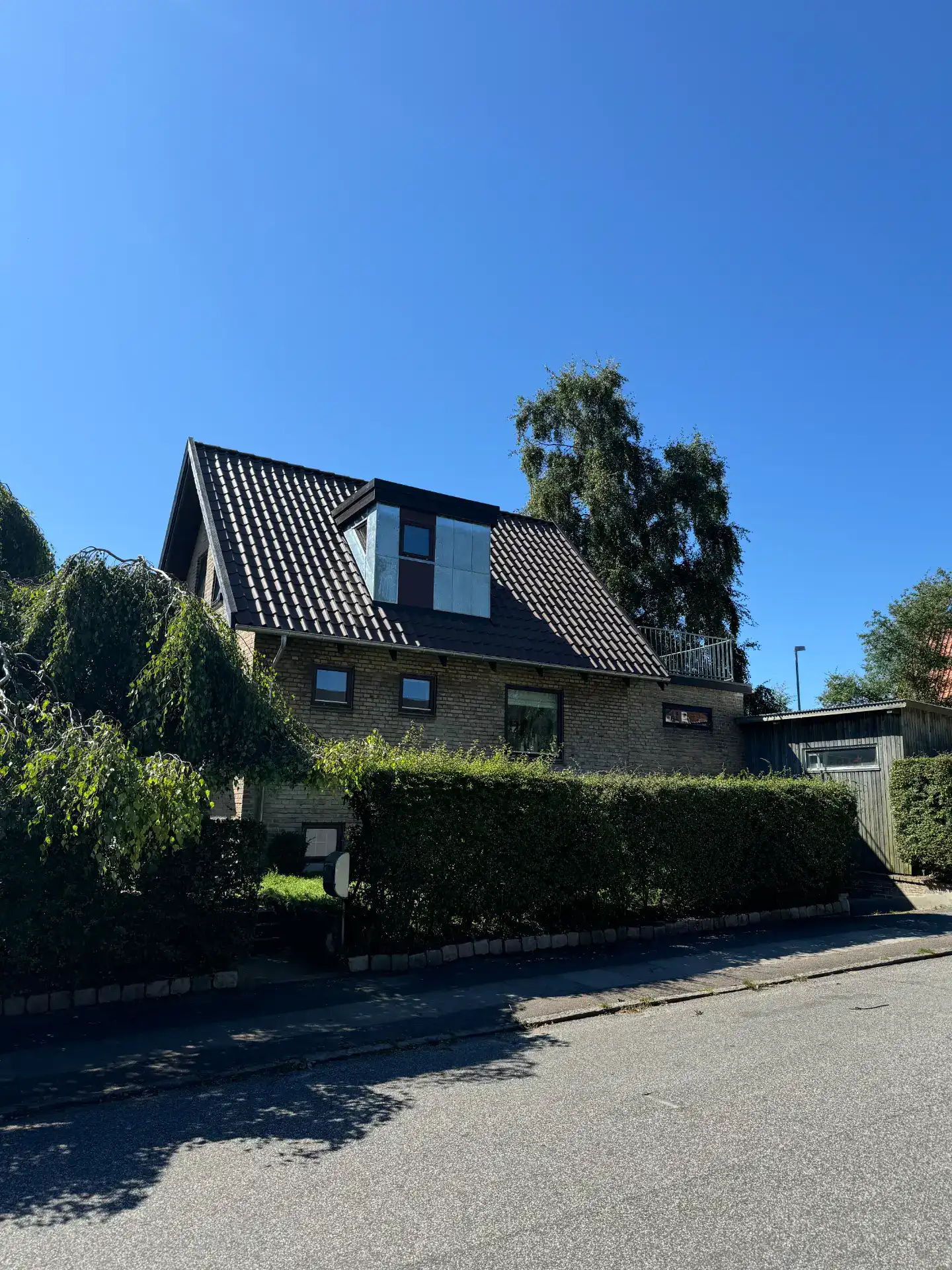 Nyrenoveret hus med solpaneler på taget under klar blå himmel.