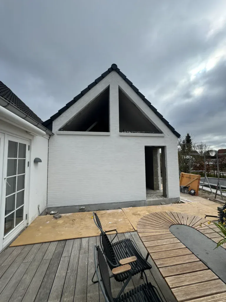 Nyt hus med moderne tagkonstruktion og hvid facade.