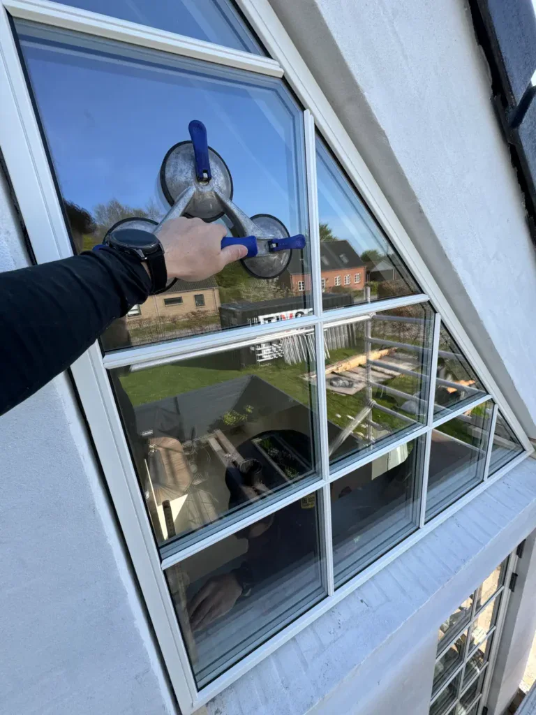 Vinduespudsning af skydelåge med professionelt udstyr.